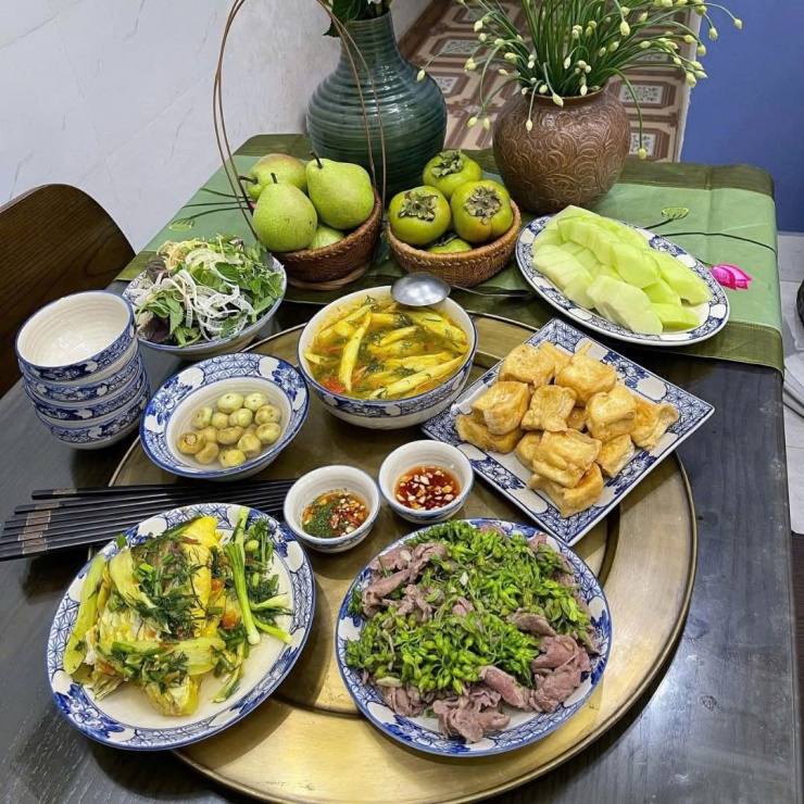 Mâm cơm ngày hè thanh mát với canh chua cá lóc, thịt bò xào, đậu rán và cà pháo muối giòn tan. Tráng miệng bằng trái cây tươi mát.