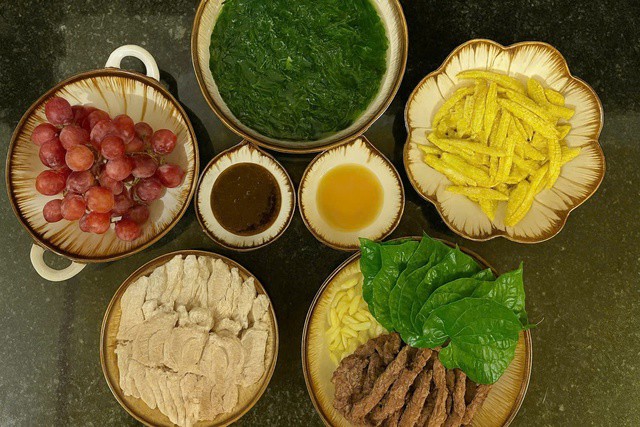 Món ăn ngon trong mâm cơm này có: Bắp bò luộc cuộn lá lốt + thịt luộc + khoai tây chiên + canh rau + quả nho tráng miệng.