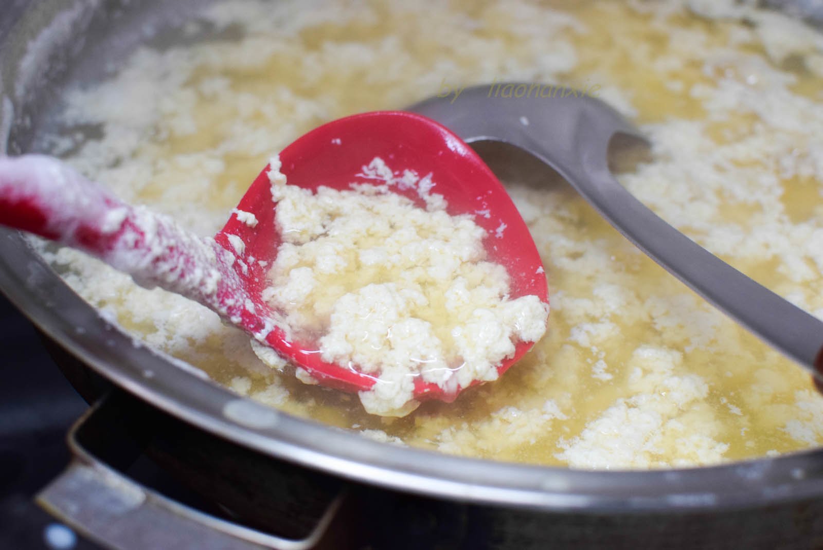 Khi sữa đậu sôi, vừa khuấy vừa rót từ từ nước chua vào.