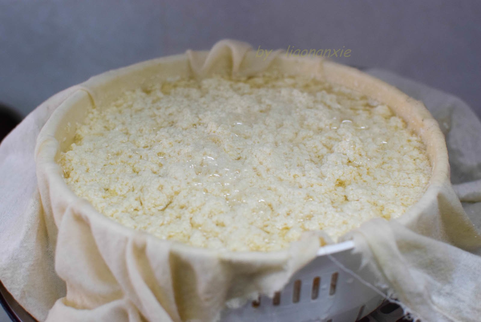 Trải vải màn trong rổ thoát nước, múc đậu hũ non vào.