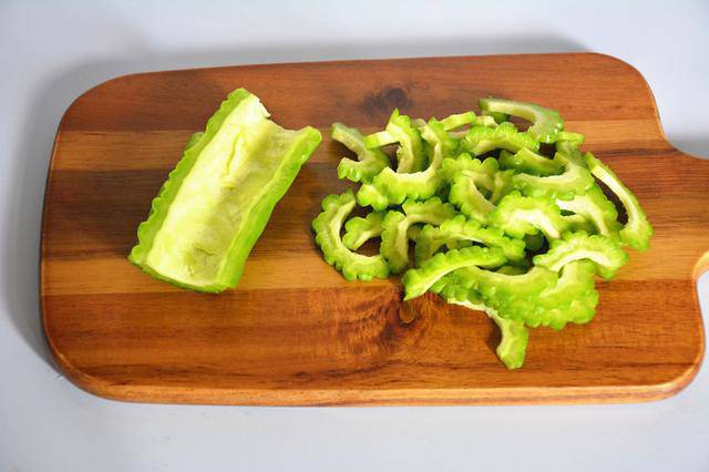 Khổ qua bổ đôi, bỏ ruột trắng, thái lát.