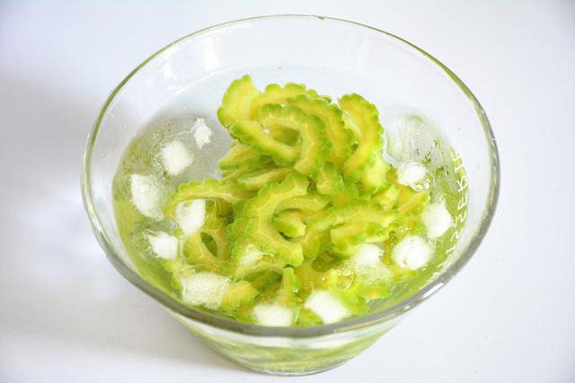 Vớt ra, cho ngay vào tô nước đá ngâm 5 phút để khổ qua giữ màu xanh mướt và giảm hẳn vị đắng.